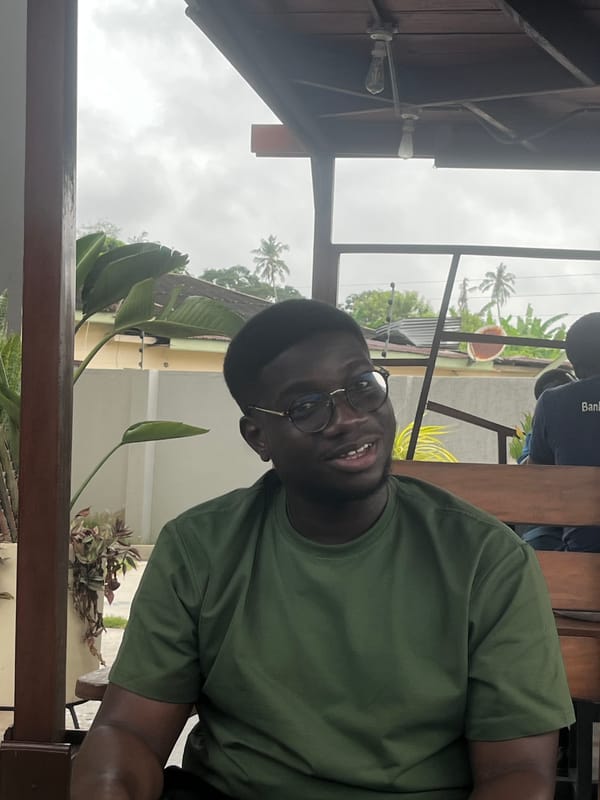 Man in green shirt photographed at table in Accra