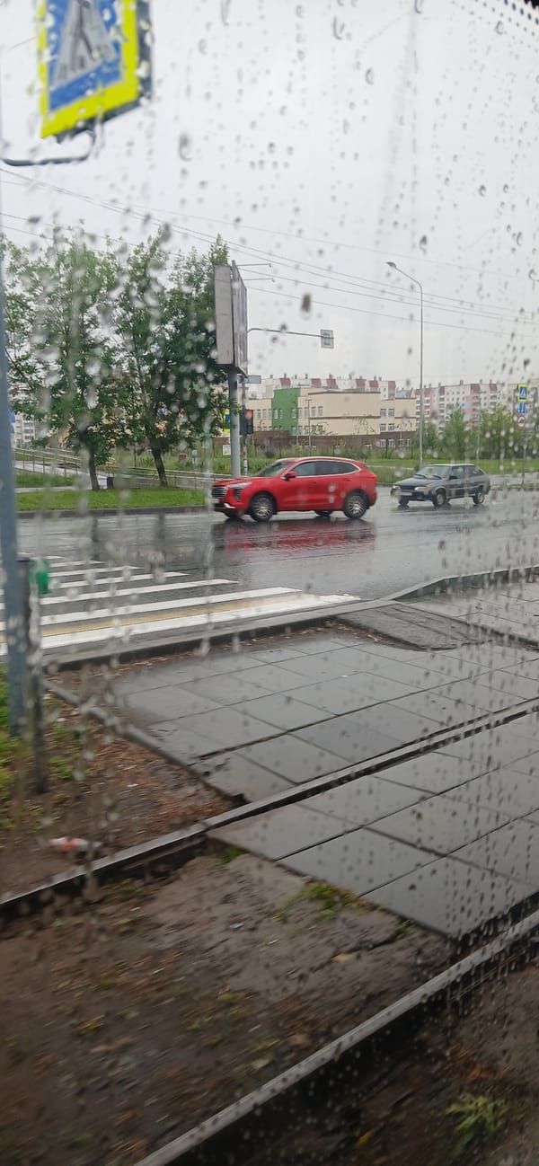 Wet Chelyabinsk streets and rail tracks seen through a rain-streaked window