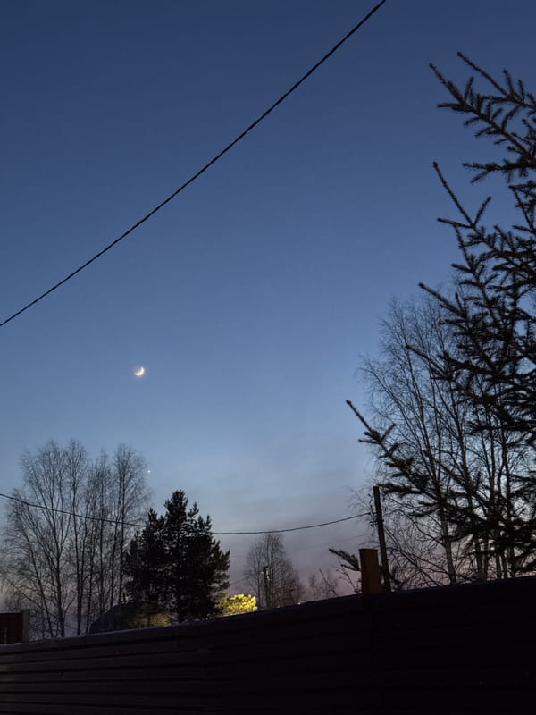 Crescent moon photographed over Russian town with power lines