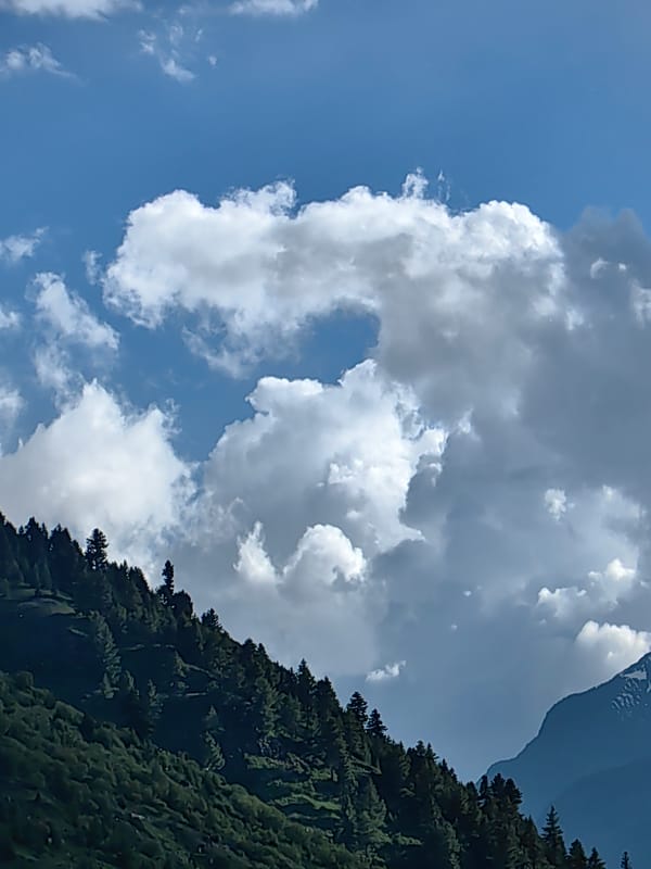 Keylang's Himalayan peaks, skies, and village on a June afternoon
