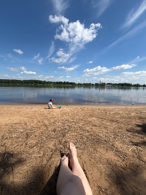 Mother and child enjoy sunny morning at Yaroslavl riverfront beach