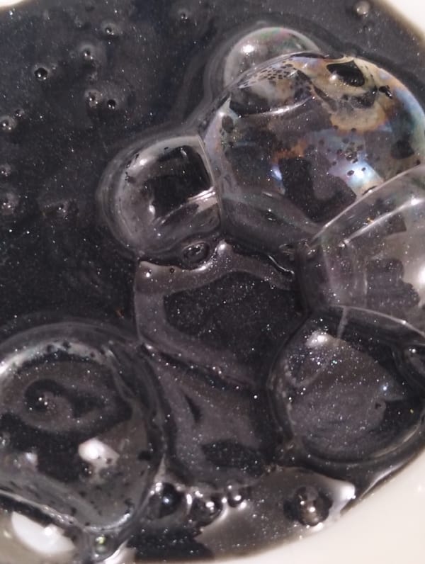 Mysterious bubbling black liquid observed with iridescent properties