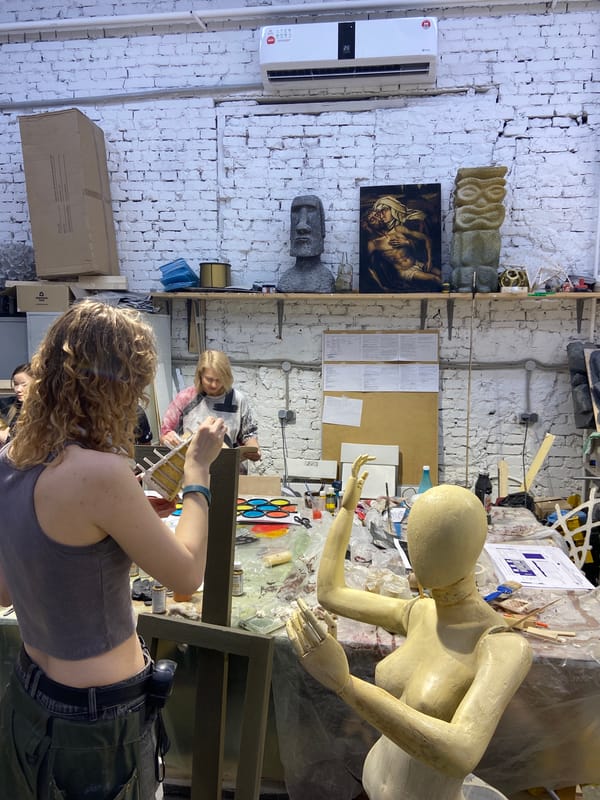 Woman works in bustling Moscow art studio during daylight