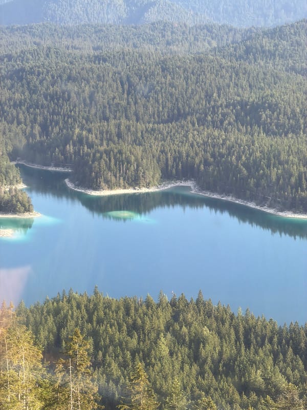 Alpine lake, forest, and cable car at Grainau's Zugspitze