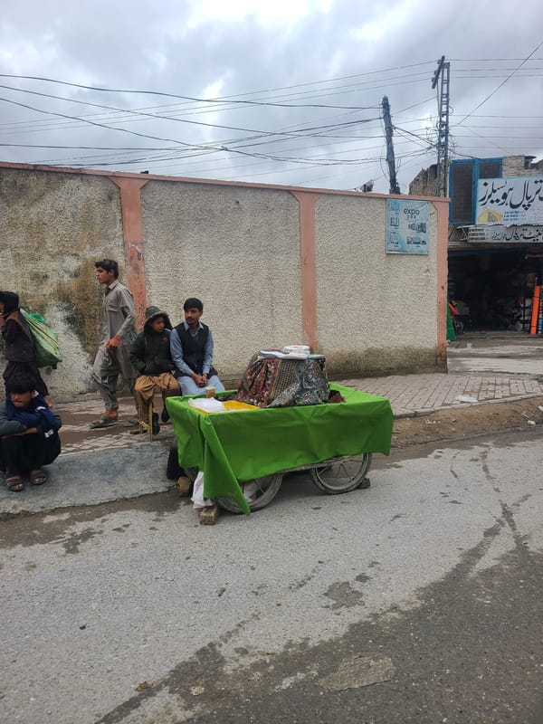 Morning street activity with fabric vendor and motorcycles in Quetta