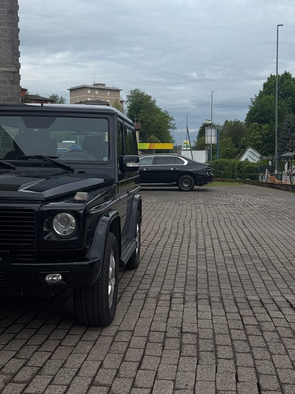 Two cars parked in Como under overcast morning sky