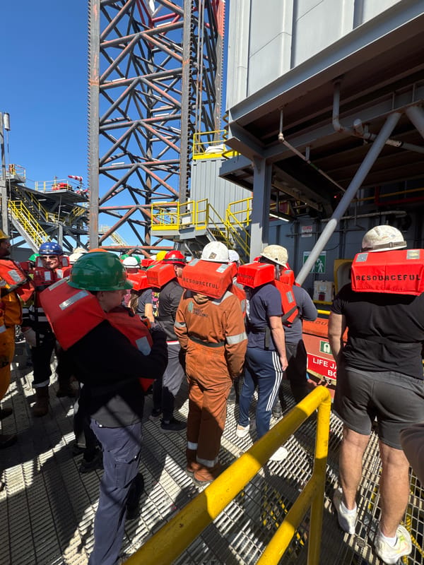 Workers in safety gear gathered on metal platform in Italy