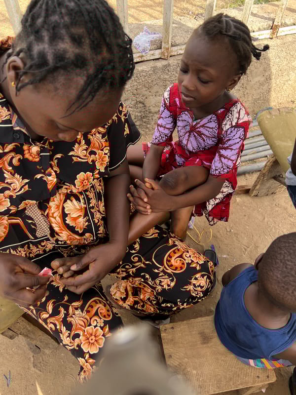 Everyday moments captured in Minna: child with woman, man carrying box