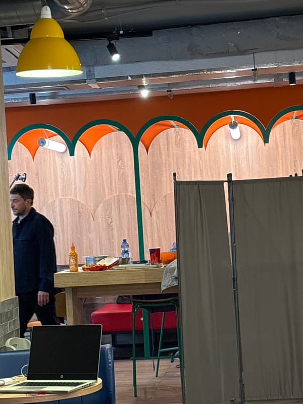 Man checks phone at workspace table in Milan