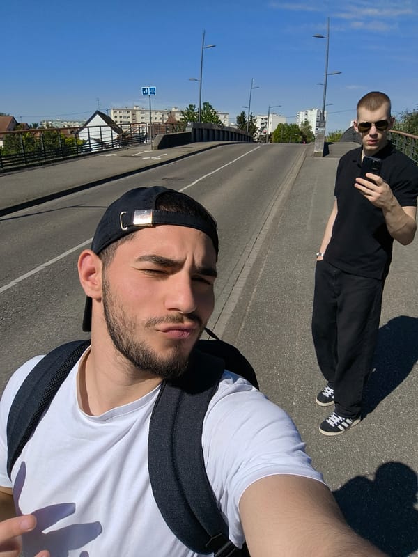 Two men take selfies on bridge in Hoenheim, France