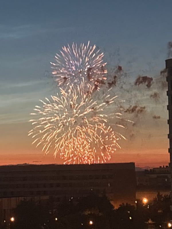 Fireworks light up a city skyline at dusk