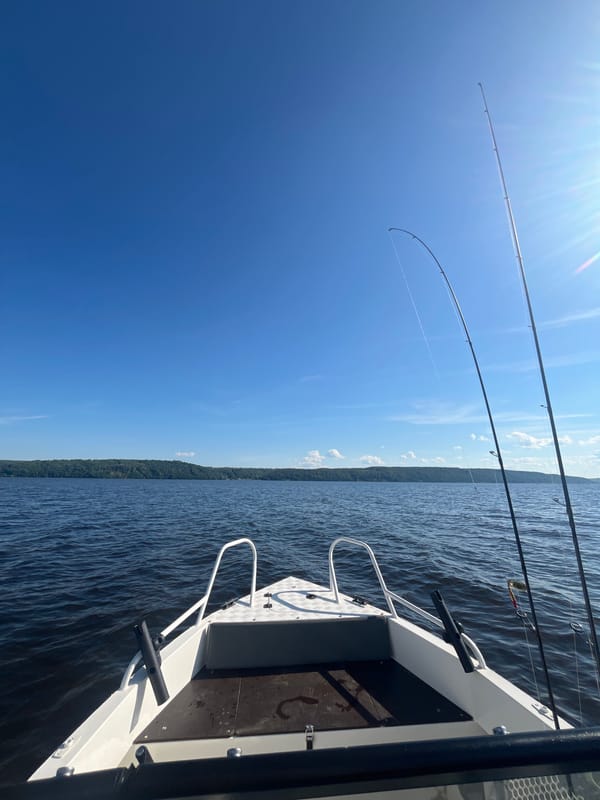 Fishing boat out on sunny Russian lake waters at midday
