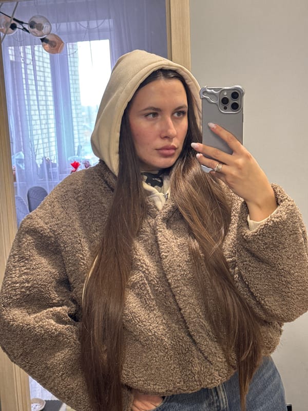 Woman takes selfies in brown hoodie in Odintsovo