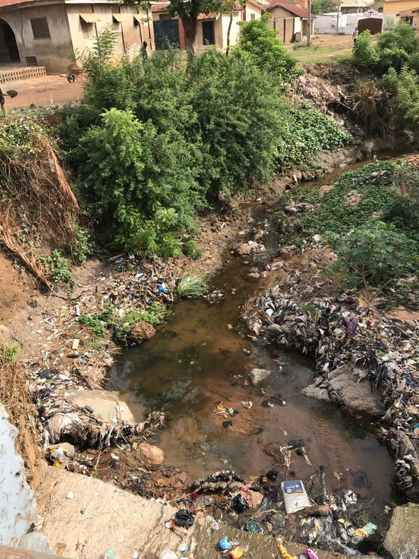 Polluted waterway choked with debris observed in Ilorin, Nigeria