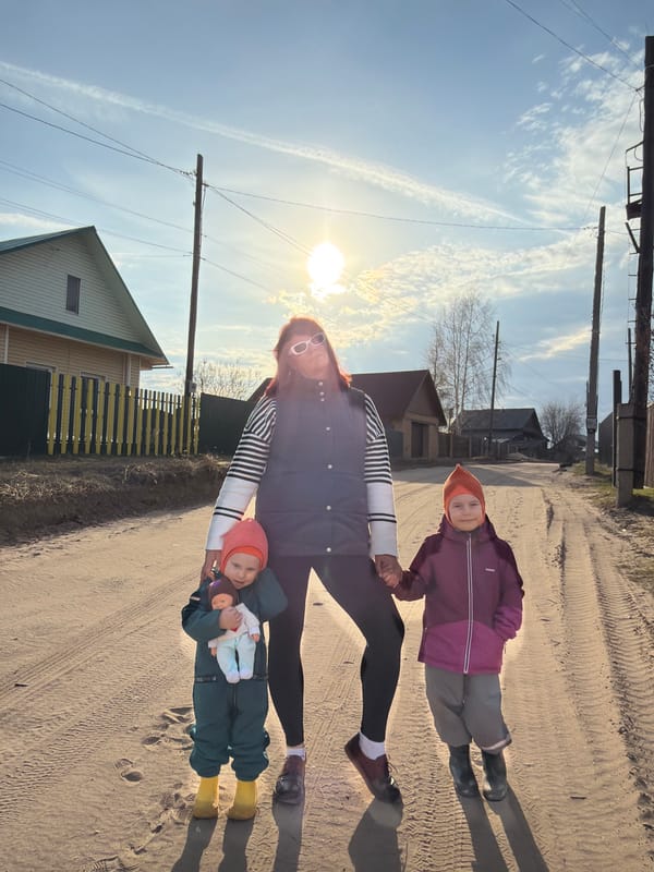 Family walks dirt road in rural Chaikovsky, Russia