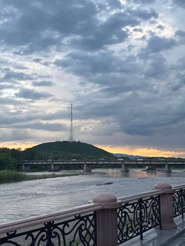 Morning scenes documented along riverside promenade with sculptures, pedestrians
