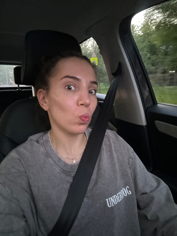 Driver's seat selfie in Moscow, 'UNDERDOG' sweatshirt, seatbelt on