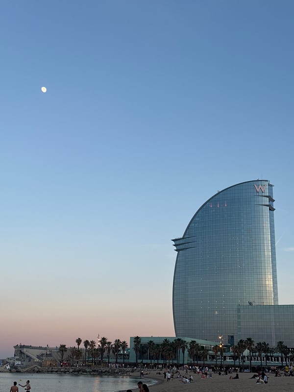 Evening beachgoers gather at Barcelona's Barceloneta Beach near W Hotel