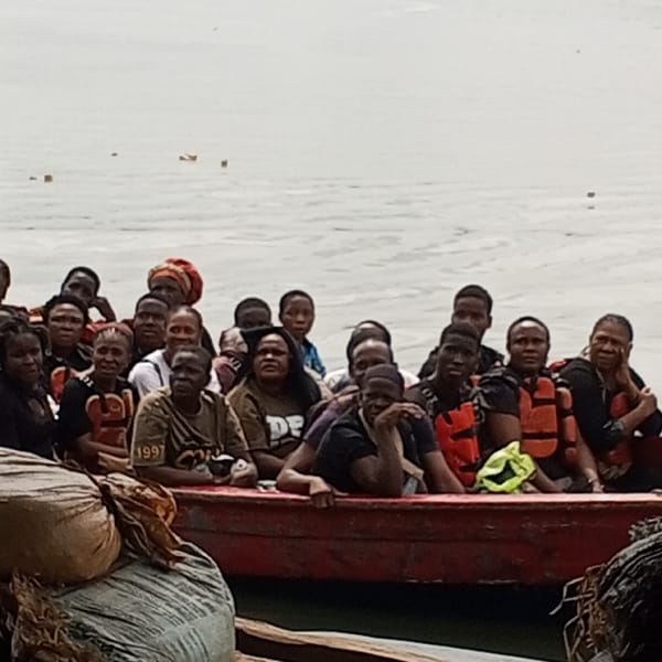 Crowded red boat carries 20+ adults on water