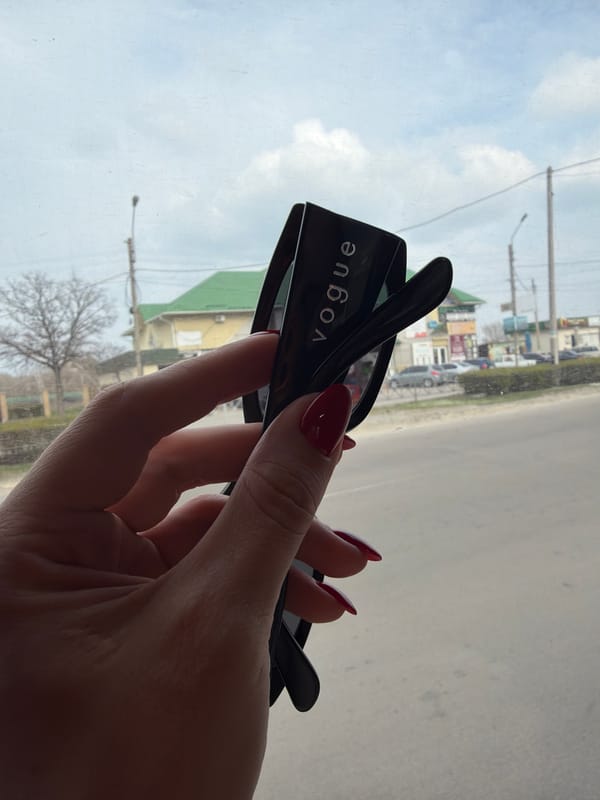 Person shows off Vogue sunglasses in Kamianske window
