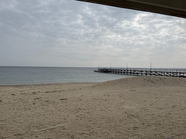Overcast day at Ravda beach with wooden pier