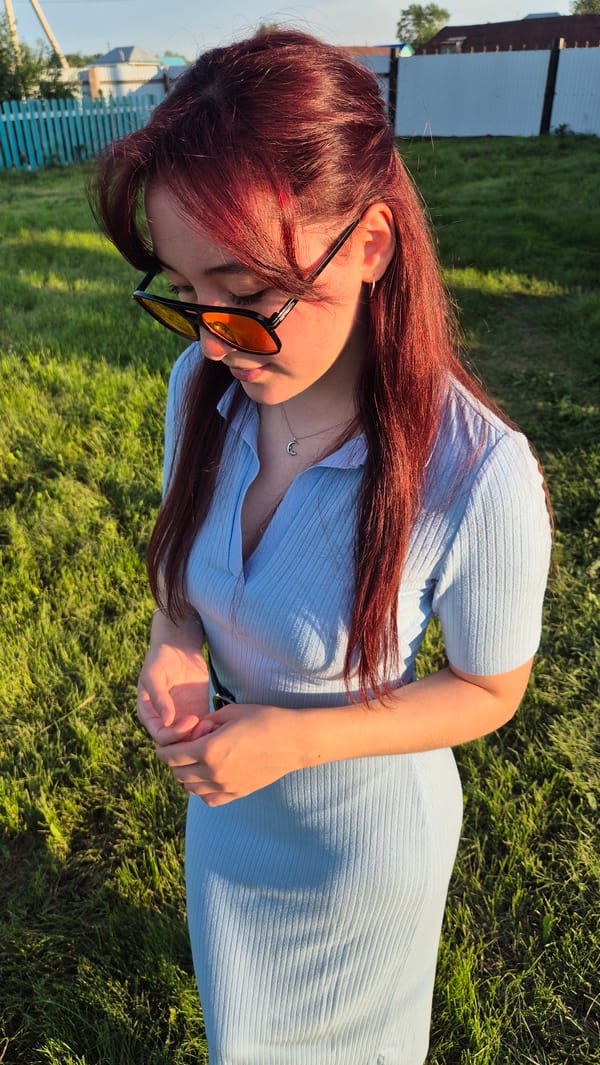 Outdoor photo session on a grassy field with sunglasses and makeup