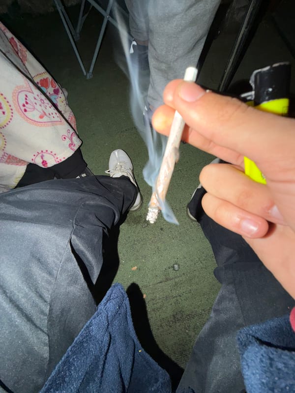 Person smoking rolled cigarette indoors in Vila Real