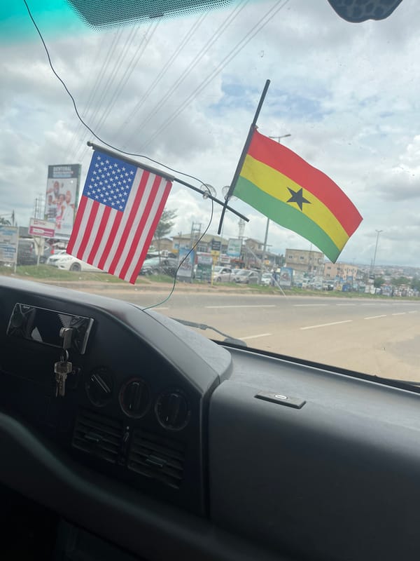 Vehicle interior captured with flags on windshield in Ablekuma