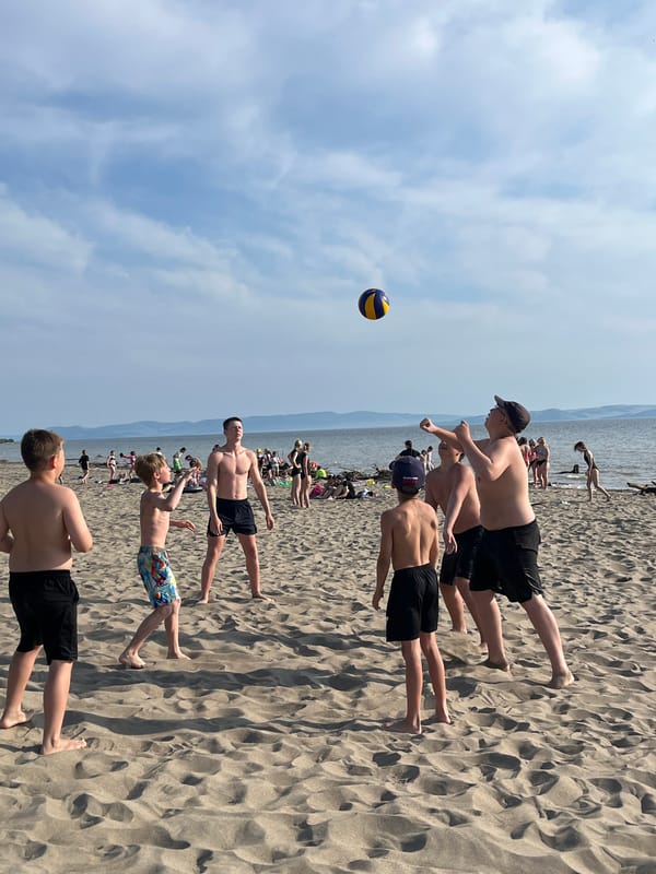 Beach day on a Russian lake — volleyball, sun, and mountain views