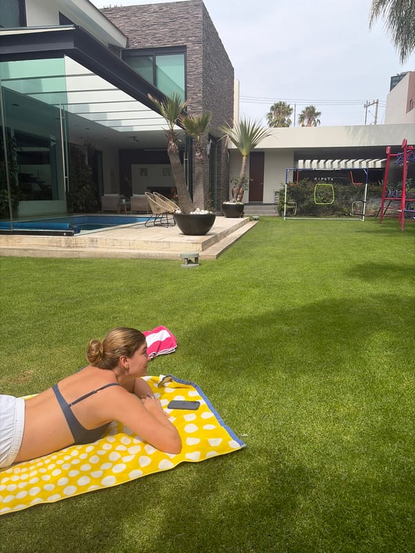 Women observed relaxing on residential lawn during evening hours