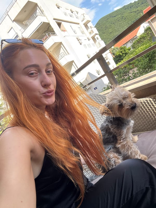 Woman and Yorkshire Terrier enjoy morning on Budva balcony