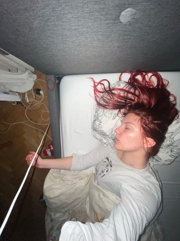 Person with red hair photographed resting on bed in Sofia