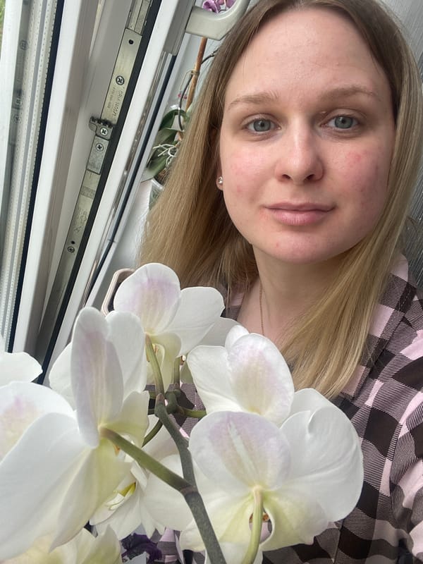 Woman poses with orchids in Russian home