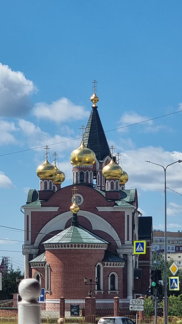 Summer morning streets in Megion, Orthodox domes and petunias