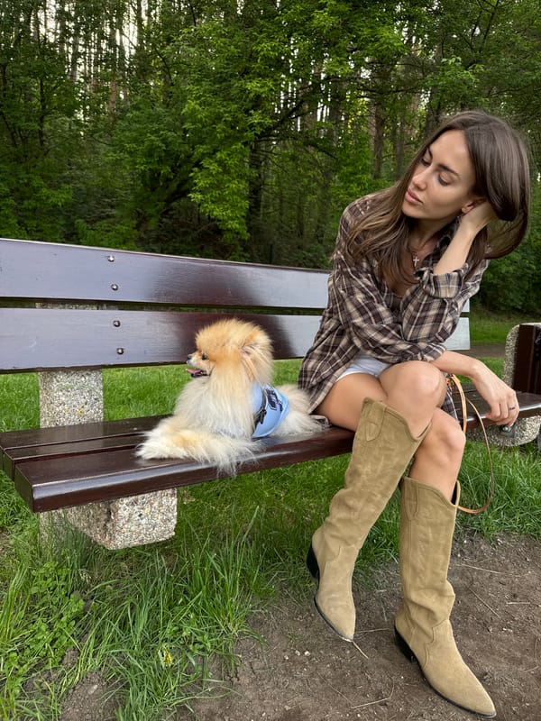 Woman and Pomeranian share quiet bench moment at park