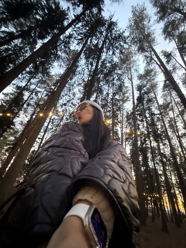 Person admires fairy-lit forest canopy in Votkinsk at dusk