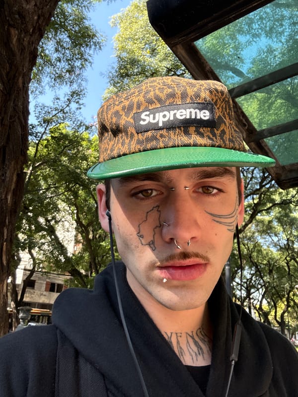 Person with facial piercings spotted wearing Supreme cap in Buenos Aires
