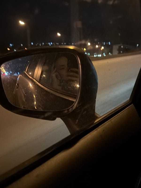 Rainy night cityscape reflected in car mirror, Chaikovsky Russia
