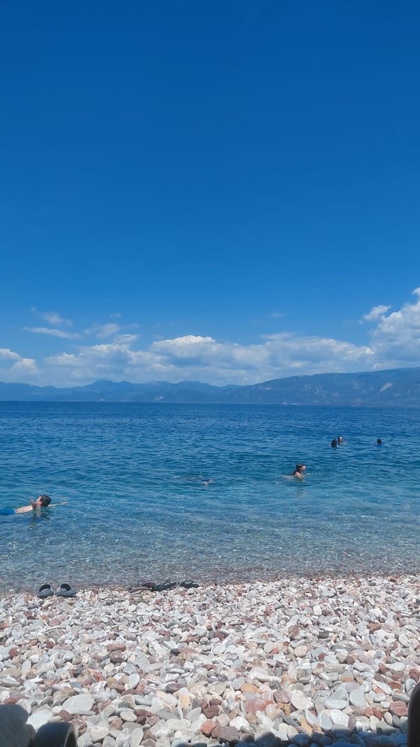 Summer morning at a pebble beach in Aegio, Greece