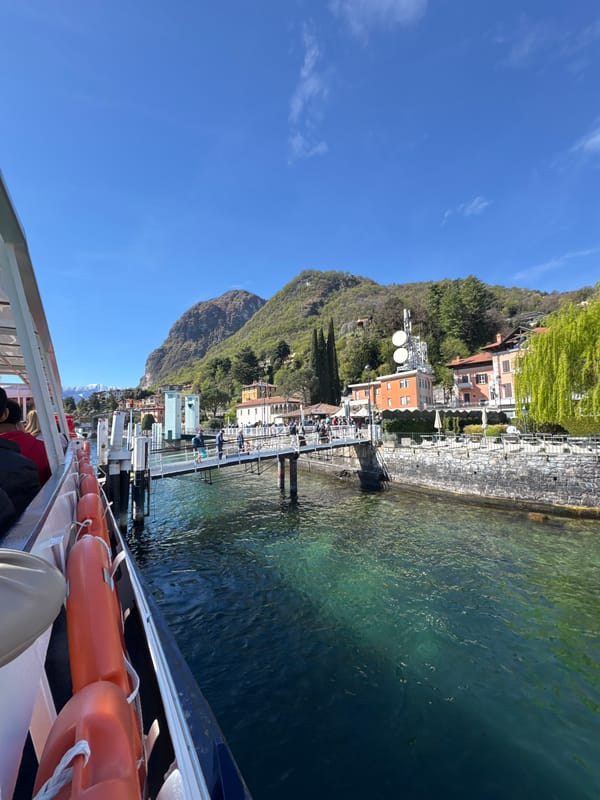 Boat passengers view Loveno waterfront during sunny Lake Como trip