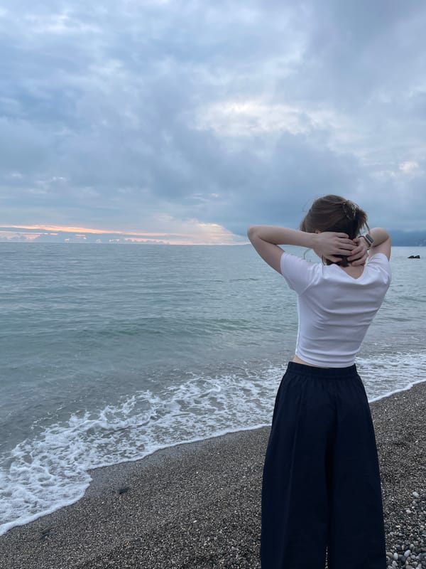 Beachgoers photographed on Gagra pebble beach during cloudy afternoon