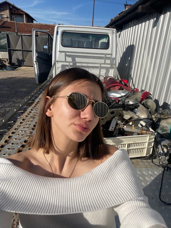 Woman photographed at Sofia junkyard amid damaged vehicles