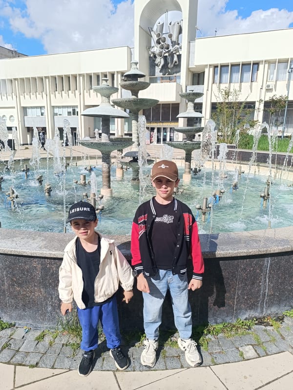 Two boys play at fountain and heart bench in Simferopol