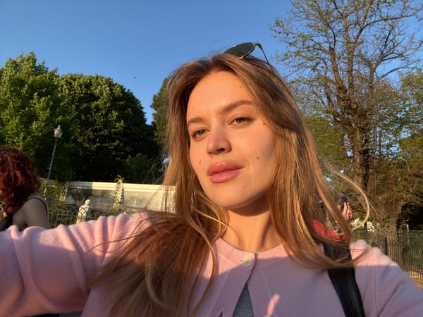 Woman visits Roman garden with marble sculptures, city views