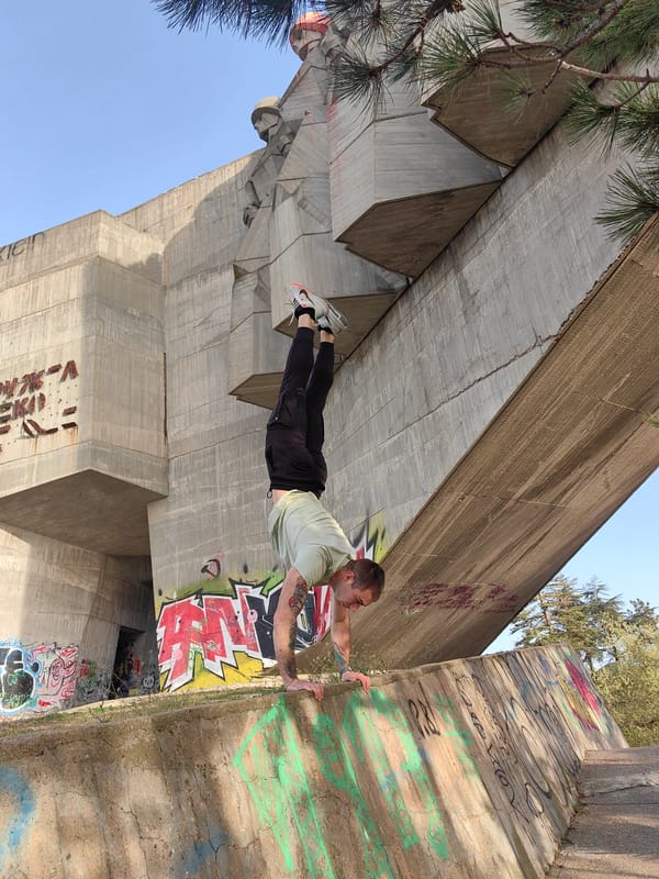 Man performs handstand at Bulgarian-Soviet Friendship Monument in Varna