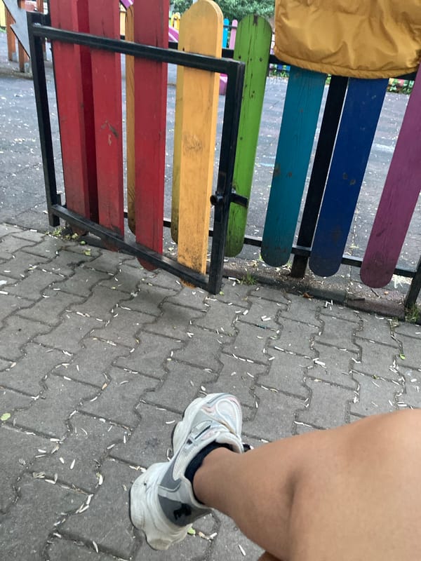 Sneaker on pavement and a rattle in a tiny hand