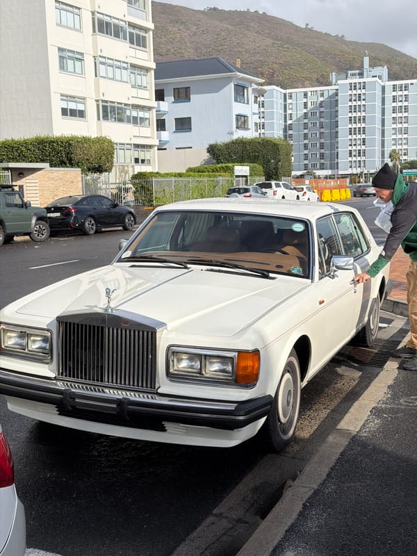 Person enters white Rolls-Royce on Cape Town street
