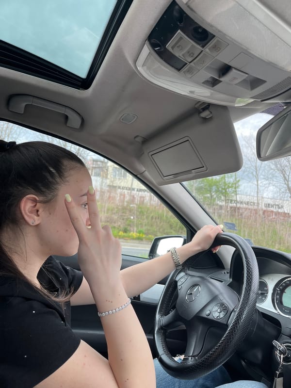 Woman driving under overcast skies captured in car interior