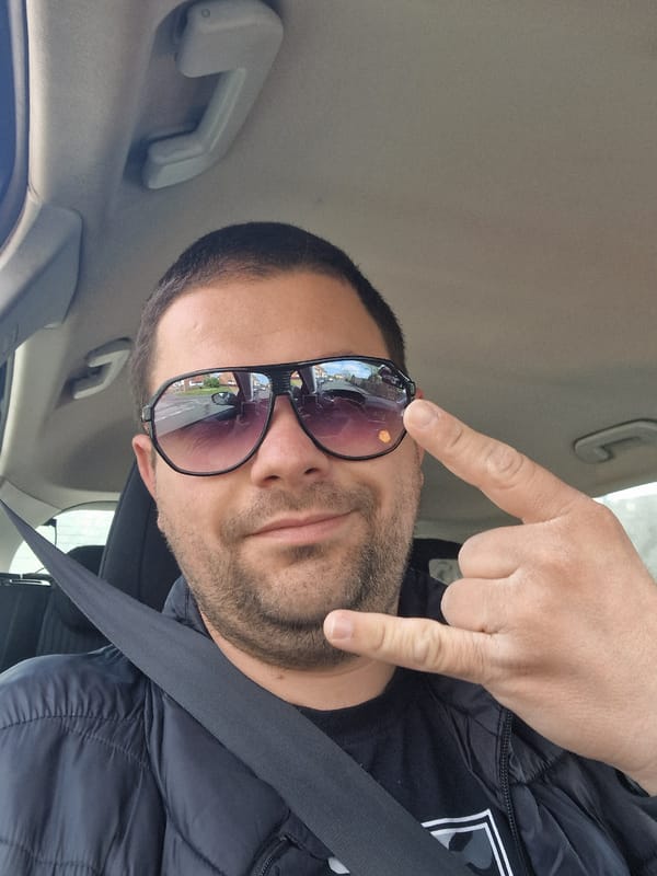 Man makes rock gesture in car passenger seat