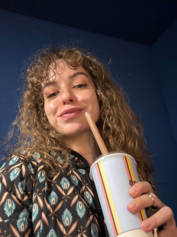 Woman drinks from striped cup in Moscow indoor setting